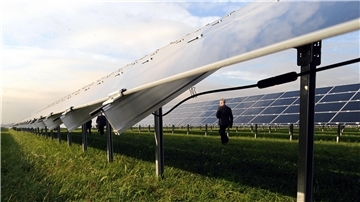 Ein Mann läuft durch einen Solarpark.