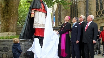 Franz-Josef Overbeck (l) enthüllt 2011 mit Gästen die Skulptur für den verstorbenen Franz Kardinal Hengsbach.