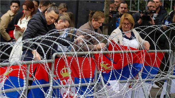 Serben im Nord-Kosovo demonstrieren weiter Frauen befestigen serbische Flaggen an einem Zaun vor dem Rathaus während einer Demonstration in der Stadt Zvecan im Norden des Kosovo.