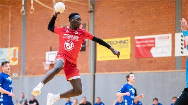 EIn Mann mit einem Ball in der Hand springt auf ein Handballtor zu.