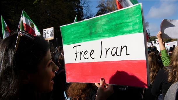 „Free Iran“ hat eine Demonstrantin auf die Landesfarben geschrieben.