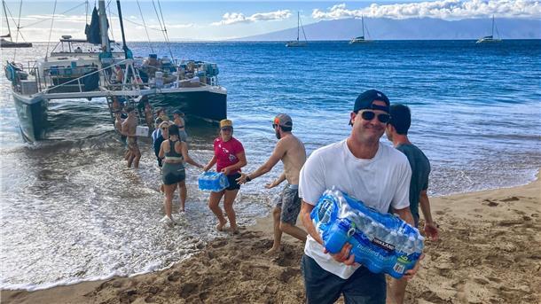 Freiwillige aus Maalaea Bay auf Maui entladen Spenden von einem Boot.