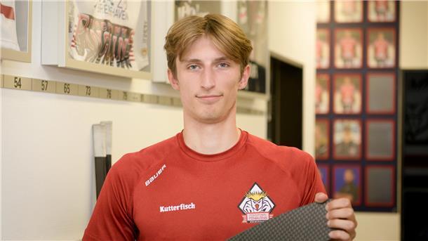 Ein Eishockeyspieler hält einen Schläger in der Hand.