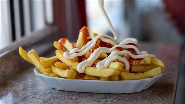Fritten mit Mayonnaise und Ketchup zu essen
