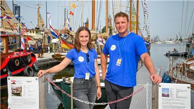 Eine Frau und ein Mann stehen am Hafen.