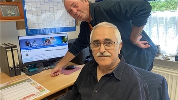Zwei Männer stehen vor einem Computer