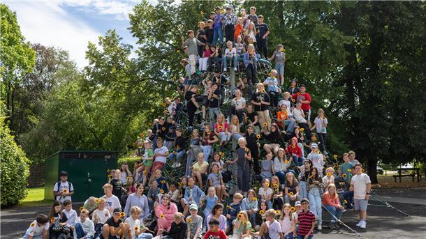 Kinder haben sich um das Klettergerüst platziert