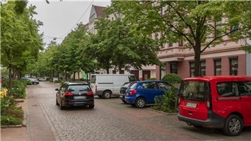 Auto fährt durch eine Wohnstraße. 