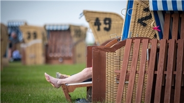 Ausgestreckte Beine ragen aus einem Strandkorb heraus
