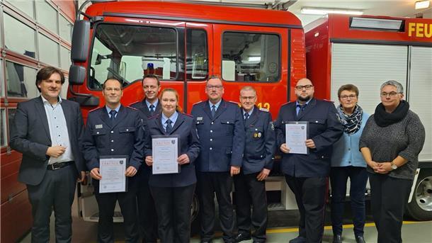 Gäste und Beförderte der Ortsfeuerwehr Schweewarden vor einem Feuerwehrfahrzeug