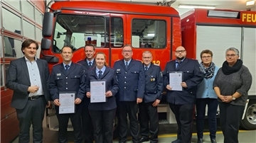 Gäste und Beförderte der Ortsfeuerwehr Schweewarden vor einem Feuerwehrfahrzeug
