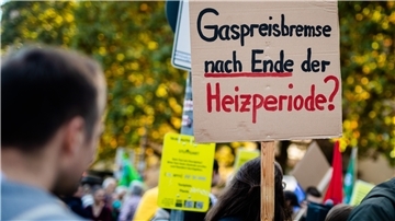 Demonstrantin mit  Plakat "Gaspreisbremse nach Ende der Heizperiode?"