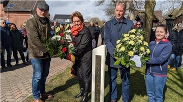 Gedenkstättenpädagoge Lars Hellwinkel (v.l.), Innenministerin Daniela Behrens (SPD), Bürgermeister Guido Dieckmann (parteilos) und Konfirmandin Lysann Schröter legen Kränze zur Erinnerung an die Todesmärsche an der Bokeler Stele ab. 
