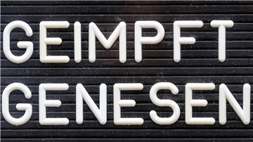 "Geimpft! Genesen!" steht auf einem Schild.