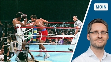 „Rumble in the Jungle“ in Zaire anno 1974: George Foreman (Mitte, rote Hose), landet einen Körpertreffer gegen Muhammad Ali (l.).