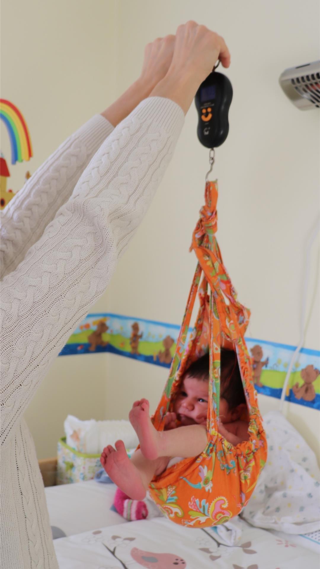 Gerade in den ersten Tagen zuhause betreut eine Hebamme die frischgebackenen Eltern intensiv und kommt fast täglich vorbei - und schaut etwa, ob das Baby gut zunimmt. Dem kleinen Mädchen scheint das Wiegen in jedem Fall zu gefallen.