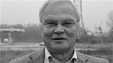 Ein älterer Mann blickt in die Kamera. Das Bild ist schwarz-weiß.  