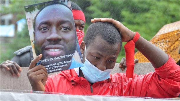 „Gerechtigkeit für Amadou Diabate“ steht auf einem Plakat, das ein Demonstrant in die Höhe hält. Es zeigt das Konterfei des in Zeven getöteten Ivorers.