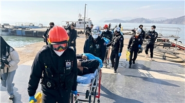 Gerettete Besatzungsmitglieder werden von Rettungskräften auf Bahren getragen, als sie in einem Hafen in Mokpo in Südkorae ankommen.