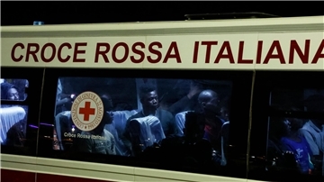 Gerettete Menschen sitzen in einem Bus, nachdem sie auf Lampedusa von einem Boot gestiegen sind.