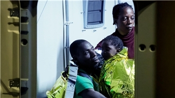 Gerettete Migranten gehen auf der italienischen Insel Lampedusa von einem Boot an Land.