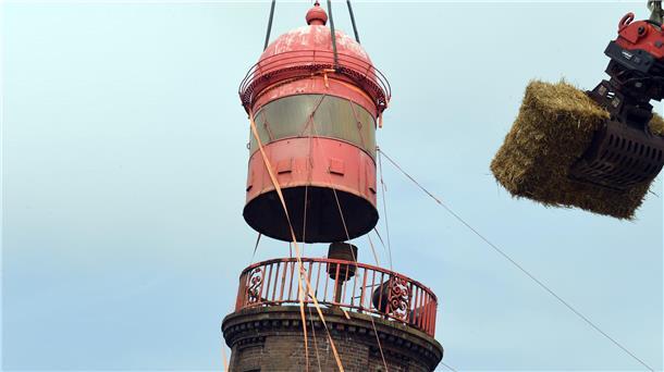 Rückblick auf das Drama um den schiefen Molenturm: Kippt er oder kippt er nicht? Geschafft: Am Freitag, 26. August, um 15.04 Uhr baumelt die knapp vier Tonnen schwere Kuppel am Haken des Mobilkrans und schwebt sachte auf den Ponton. Der Strohballen soll im Fall des Falles einen Aufprall abmildern. Hunderte Schaulustige verfolgen die Bergung live mit.