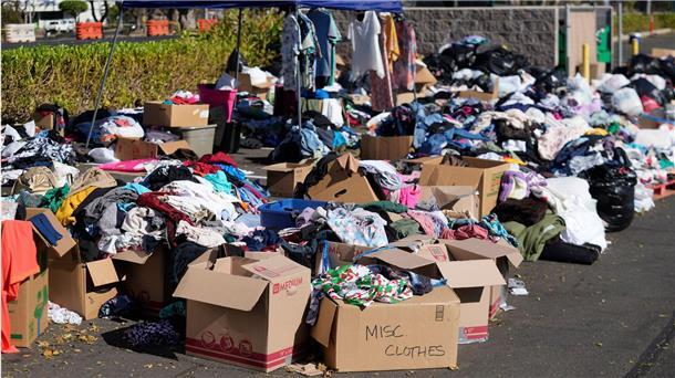 Gespendete Kleidung wird in Lahaina, Hawaii, auf einem Parkplatz gesammelt, nachdem die Waldbrände schwere Schäden verursacht haben.