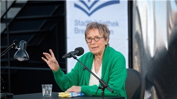 Gisa Pauly liest aus einem Buch.