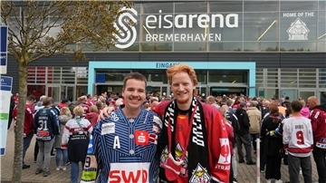 Zwei Fans der Fischtown Pinguins stehen vor der Eisarena Bremerhaven.