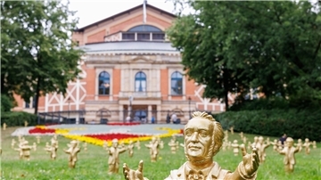Goldfarbene Wagner-Figuren des Konzeptkünstler Ottmar Hörl stehen im Rahmen der Kunstinstallation „You’re welcome“ vor dem Festspielhaus.
