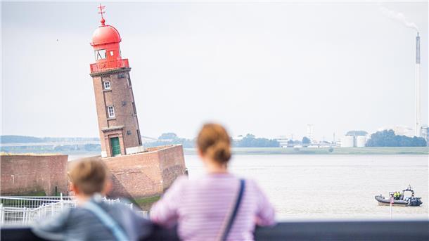 Zwei Menschen blicken auf den schiefen Turm der Nordmole.