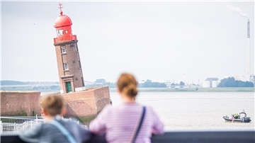 Zwei Menschen blicken auf den schiefen Turm der Nordmole.