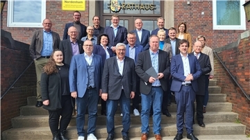 Eine Gruppe steht auf einer Treppe des Nordenhamer Rathauses