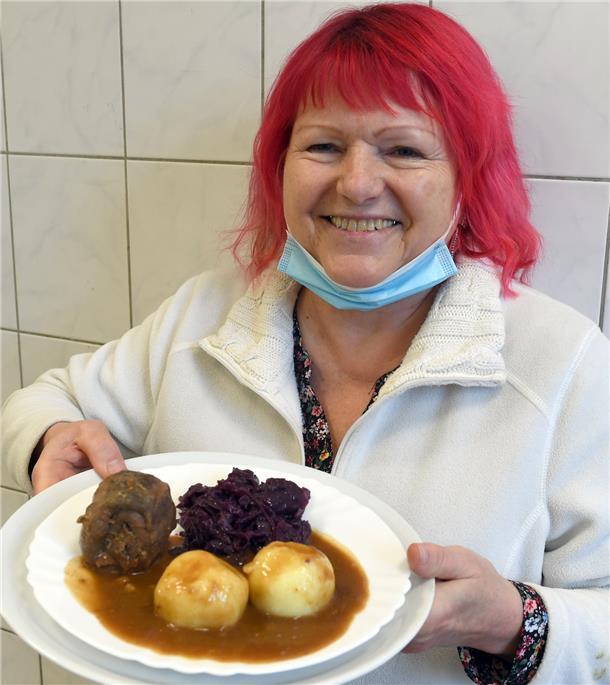 Eine Frau hält einen Teller mit Essen in den Händen