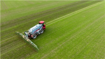 Ein Landwirt bringt mit seinem Gespann Gülle im sogenannten Schleppschuh Verfahren auf einem Feld aus