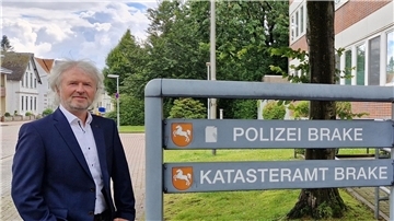 Ein Mann steht vor dem Katasteramt in Brake.