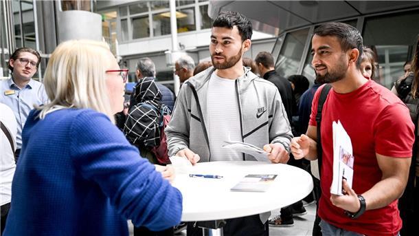 Gulan und Achmad aus Afghanistan informieren sich auf der Jobmesse „FuTog Berlin“ (FutureTogether Berlin) für Geflüchtete.