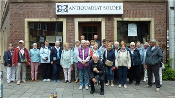 Mitglieder des SoVD Wilstedt stehen für ein Gruppenfoto vor einem Gebäude. 
