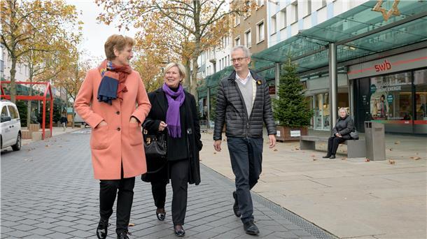 IHK-Rundgang in der Innenstadt: Einzelhändler schauen nach vorne Drei Leute laufen durch die Fußgängerzone.