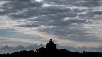 Hamburg, Neuwerk: Wolken hängen über dem Leuchtturm auf der Nordseeinsel.