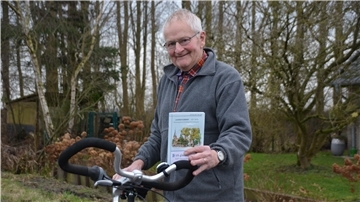 Ein Mann hält ein Fahrrad 