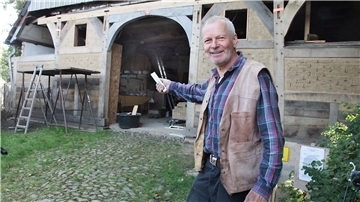 Hans-Hermann Bohling vor dem Vordergiebel des ältesten Rhader Bauernhauses, das von ihm renoviert wird.