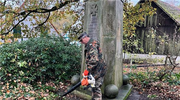 Hans-Peter Blanken befreit das Ehrenmal vom Herbstlaub.