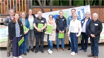 Heidi Stelljes (Dritte von rechts) und die Bezirkskommission des Wettbewerbs „Unser Dorf hat Zukunft“ vor dem Erntewagen der Landjugend.