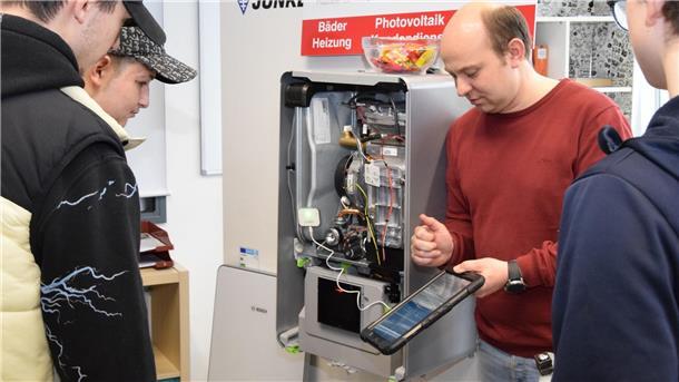 Was künftige Azubis fürs Berufsleben mitbringen sollten Heizungsbaumeister Alexander Derksen von der Firma Haus & Technik Pape zeigt Neuntklässlern vor einer Therme den Umgang mit einem Diagnosegerät