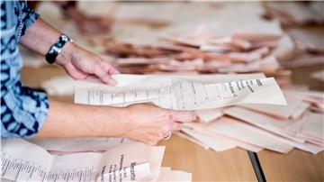 Helfer zählen die Wahlstimmen aus. In zwei Wochen kommt es neben der Bundestags- auch zu einer Stichwahl um den Landratsposten.