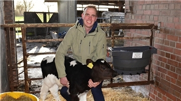 Hendrik Lübben mit einem drei Wochen alten Kalb auf seinem Hof.