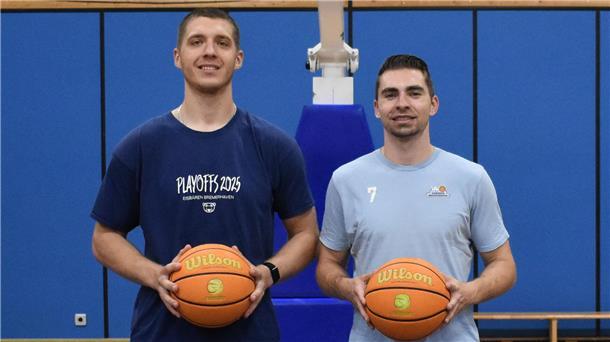 Zwei Spieler der Eisbären Bremerhaven halten einen Basketball in der Hand. 