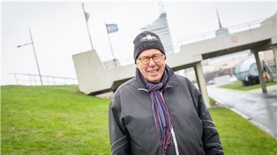 Ein Mann steht am Deich in Bremerhaven.