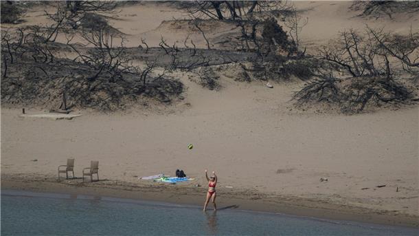 Griechische Feuerwehr: Brände größtenteils unter Kontrolle Hinten die verbrannte Vegetation, vorn das Mittelmeer. Ein Strand bei Gennadi auf Rhodos.
